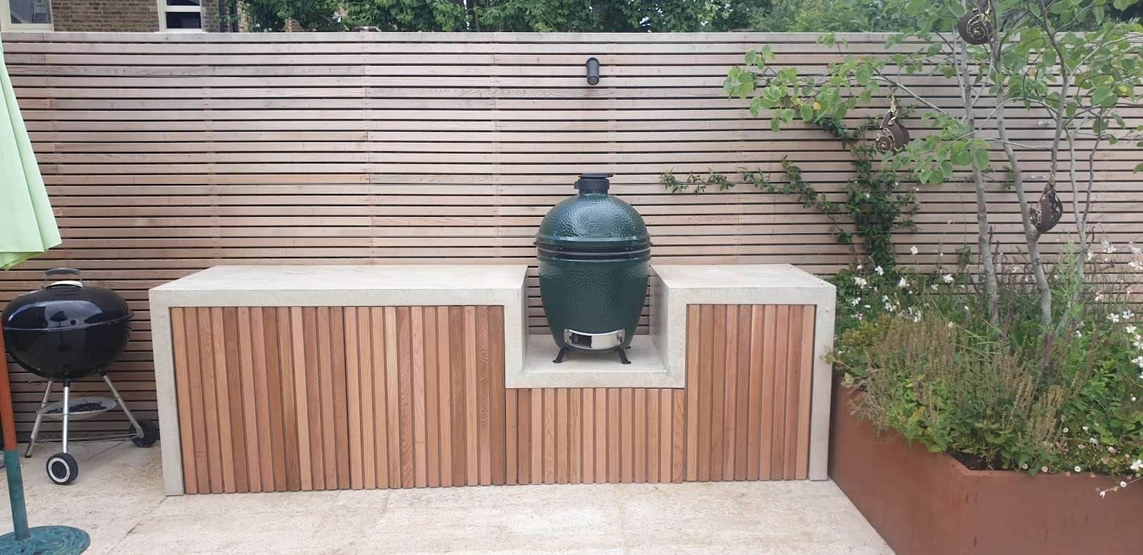 Outdoor kitchen with slatted cladding, by R Construction Ltd